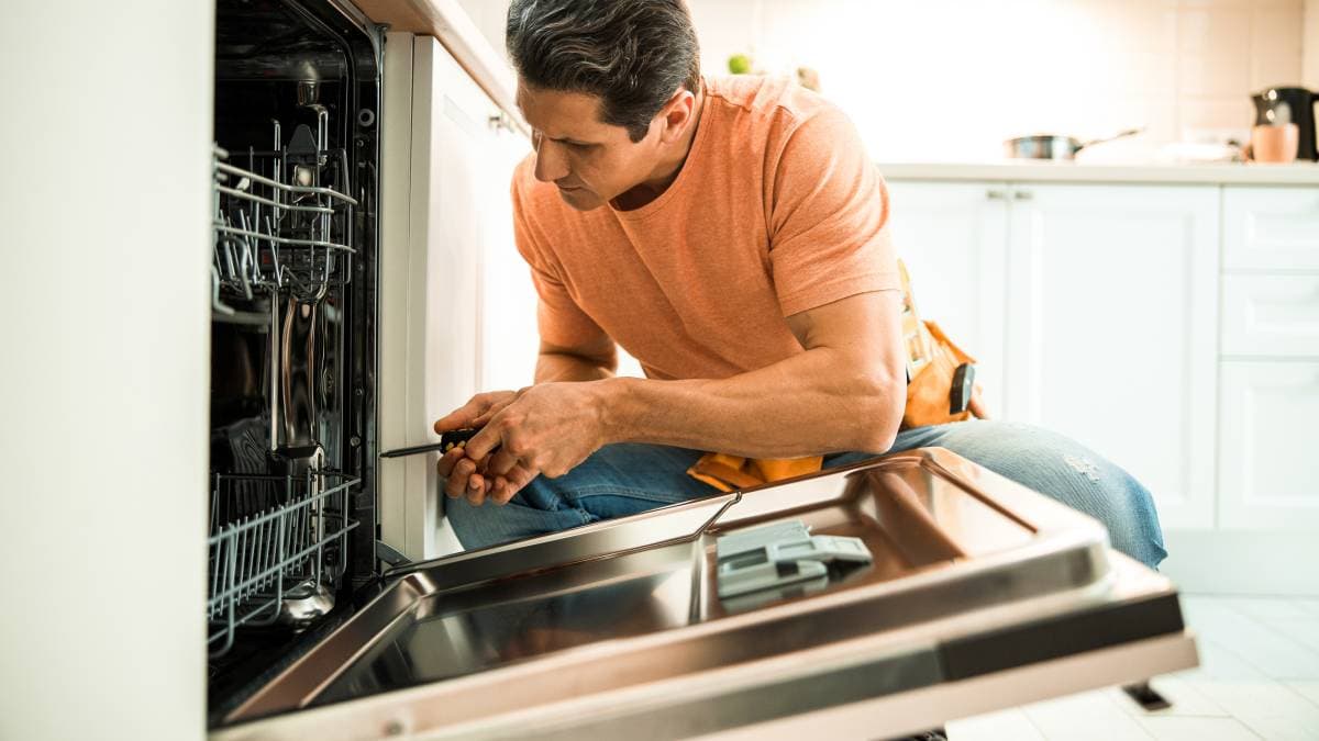 Technician repairing a dishwasher