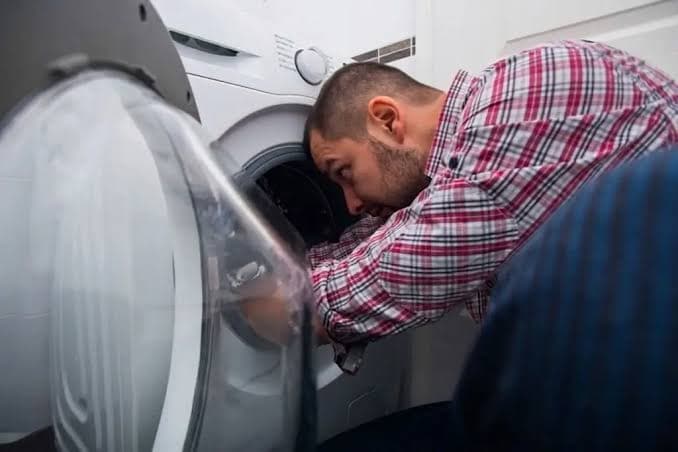 Technician repairing a dryer